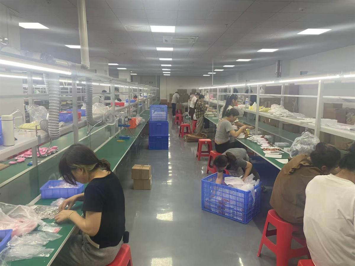 Assembly line with operators building and packing dual-head shavers at individual stations