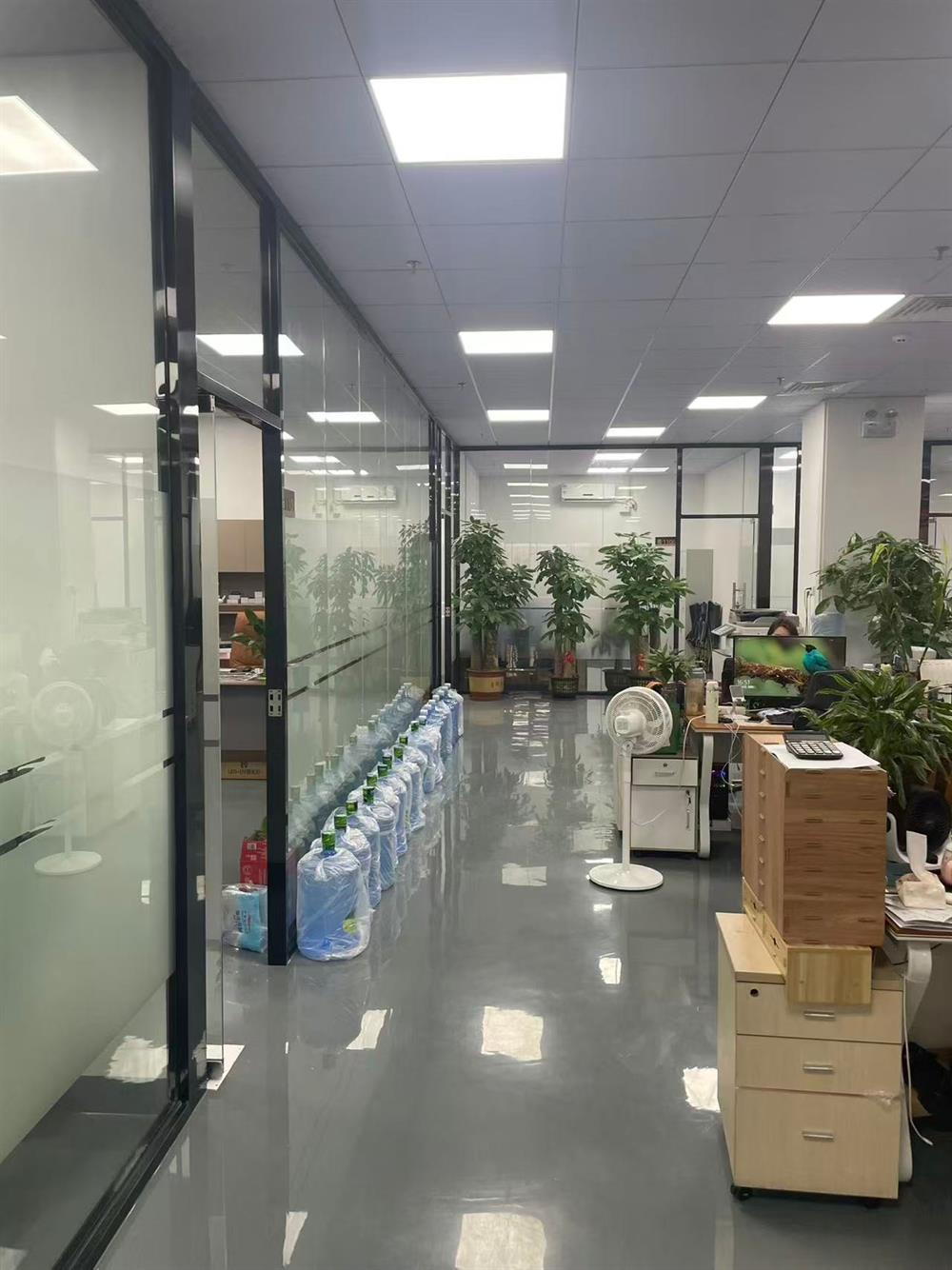 Office floor with glass meeting rooms and merchandising desks